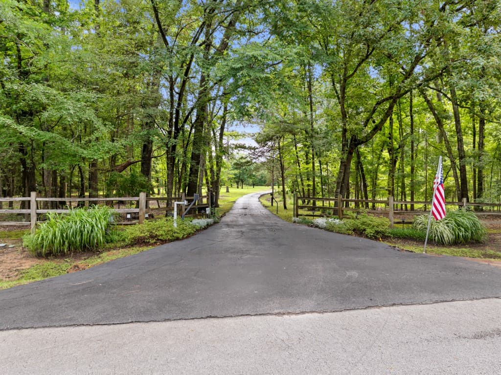 Tree-lined driveway leading to private lakeside estate in Tyler, Texas